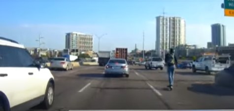Scooter rider cuts across 6 lanes of freeway traffic during rush hour