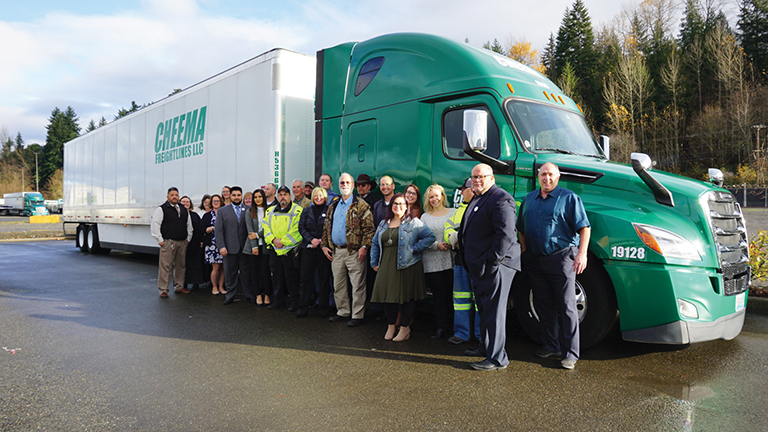 Cheema drivers in front of a green Freightliner
