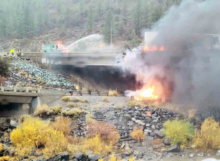 Fiery crash leaves rig dangling from bridge