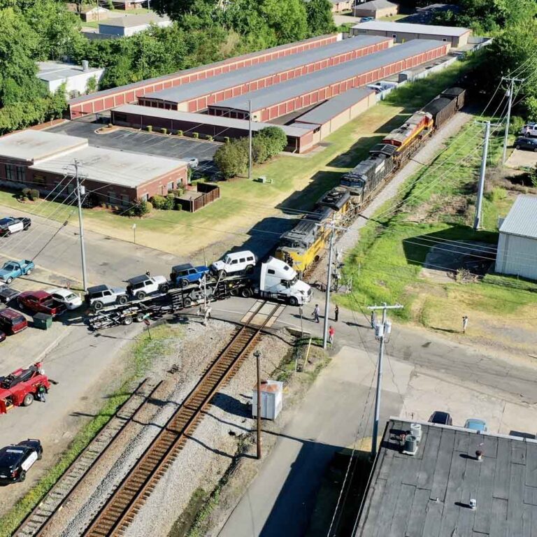 Freight train stops inches from big rig stuck on tracks