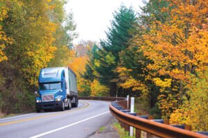 Blue semi truck on winding highway in autumn Columbia Gorge