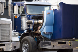 Blue big rig semi truck with open hood standing on the parking lot for repair engine and service work