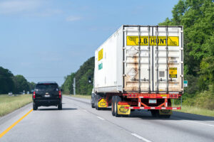 Cars and JB Hunt cargo transportation truck on interstate highway 85 i 85 road in Alabama