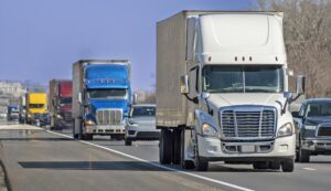 A Variety of Eighteen Wheel Big Trucks Navigate The Interstate