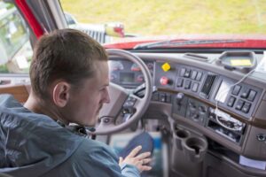 Truck driver in semi truck cab with modern dashboard