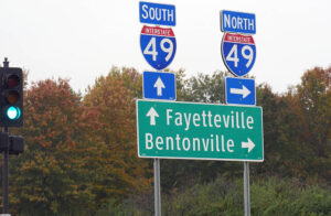 Roadside signs and directions to Fayetteville and Bentonville along Interstate 49 in Arkansas, USA.