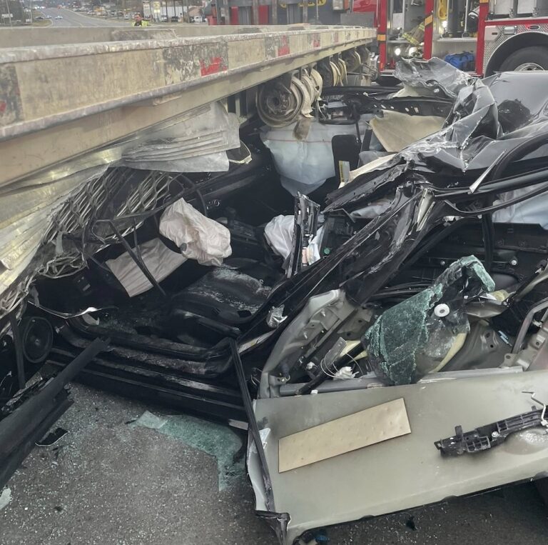 Crash with flatbed truck sends motorist to hospital