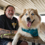 Pro driver and veteran Tom Christian and his furry, four-legged copilot travel in a True to the Troops-wrapped truck. Those Who Deliver 2