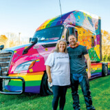 Dubbed the “Rainbow Rider,” Hirschbach driver Shelle Lichti, shown here with Hirschbach CEO Brad Pinchuk, travels the highway in a colorfully wrapped Freightliner. In addition to working to help and mentor other drivers through her 501c3 nonprofit, LGBT Truckers, she is the creator of the Facebook group Trucking Furbabies. (Courtesy: Hirschbach)