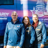 Eddie Hardy, president of Hardy Brothers Trucking, visits with Ed and Deb Kingdon at the tree’s tour stop at Veterans Memorial Park in Mount Airy, North Carolina. (Photo by James Edward Mills)