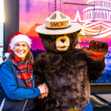 Driver Deb Kingdon poses with Smokey the Bear at one of the 2022 Capitol Christmas Tree tour stops. (Photo by James Edward Mills)