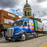 The 2022 Capitol Christmas Tree, hauled by Ed and Deb Kingdon of Hardy Brothers Trucking, rolls past the Cherokee County Courthouse in Murphy, North Carolina. (Photo by James Edward Mills)