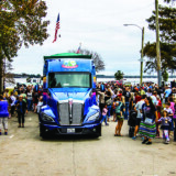 A crowd gathers around the tractor-trailer during a tour stop at Union Point Park in New Bern, North Carolina. (Photo by James Edward Mills)