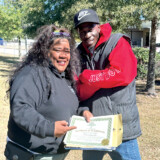 Sue Peña and one of her classmates celebrate following her successful completion of the driving portion of the CDL test. Photo by Linda Garner-Bunch/The Trucker