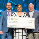 Prime Inc. driver Emily Plummer, center, shows off her $20,000 award check as a new Professional Driver of the Year awardee. (Courtesy: TCA) 23 03 07 Plummer TCA web