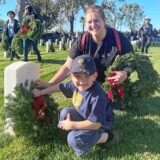 Danielle Reeves and son, Dane, from Santa Clarita, Calif., participate in Wreaths Across America on Saturday, Dec. 16, 2023, at Los Angeles National Cemetery. (Bobby Ralston/Trucker News Staff) Wreaths Across America at Los Angeles National Cemetery