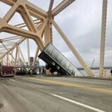 This photo provided by the Louisville Division of Fire shows a semi-truck dangling from an Ohio River bridge on Friday, March 1, 2024. bridge1