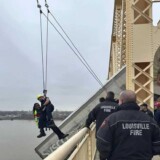 A Louisville, Ky., firefighter rescues a female truck driver after her rig crashed through the side of an Ohio River bridge on Friday, March, 1, 2024. (Courtesy: Louisville Division of Fire) bridge2