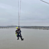 A female truck driver holds on to a Louisville firefighter after being rescued from her rig, which was hanging off the side of an Ohio River bridge on Friday, March 1, 2024. (Courtesy: Louisville Division of Fire) bridge4
