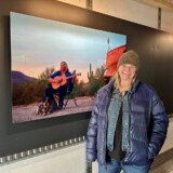 Professional driver Debbie Dingo, one of the 40 "Sisters of the Road," poses with her photograph in the touring exhibit. (Courtesy: Anne-Marie Michel Photography)