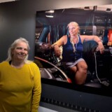 Professional driver Holly Brown, one of the 40 "Sisters of the Road," poses with her photograph in the touring exhibit. (Courtesy: Anne-Marie Michel Photography)