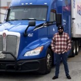 Tristan Utter, a driver for National Carriers out of Irving, Texas, stands next to his Kenworth T680. In September, on his first solo run, Utter found himself trapped in North Carolina in the middle of Hurricane Helene. (Courtesy: National Carriers)